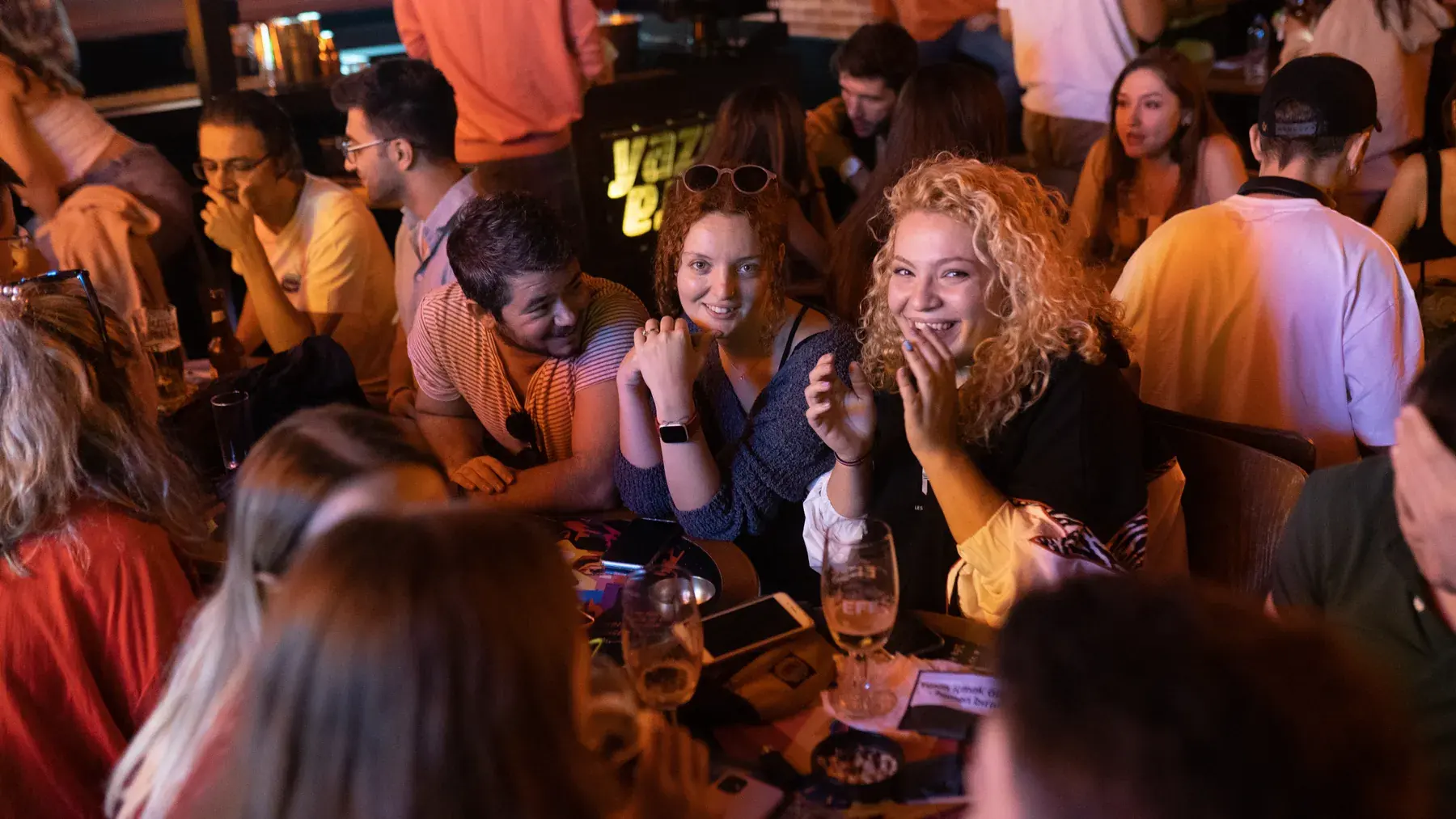 Friends laughing together around the tables at Yazı Tura Barcade, Istanbul